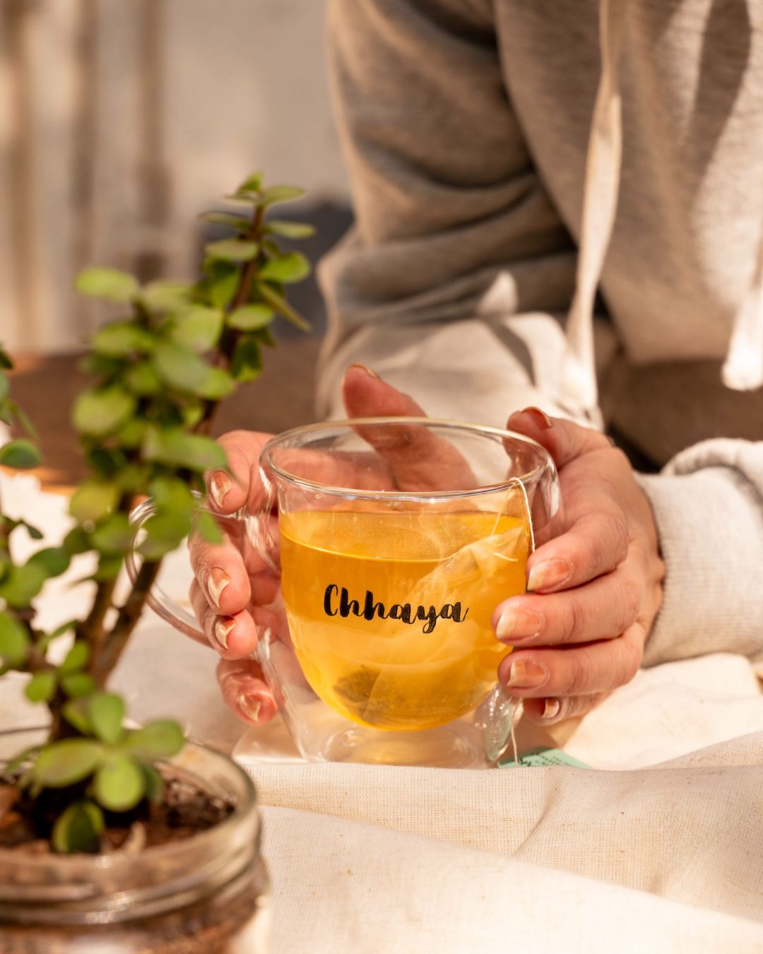 Double Wall Mug mit „Chhaya“-Gravur, goldgelbem Getränk in klarem Glas